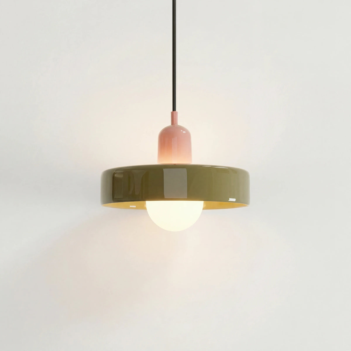 Pink and green mid-century mera pendant light suspended elegantly against a white wall