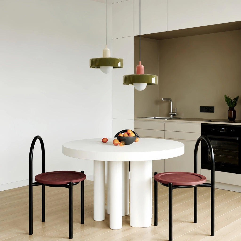 Two retro colour-block mera pendant lights in green suspended over a modern round dining table