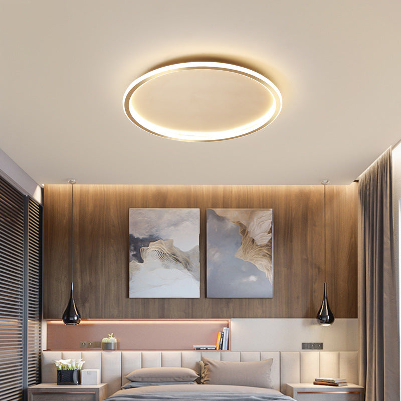 Elegant gold halo ring LED merqi ceiling light adding warmth to a modern bedroom with wood panelling