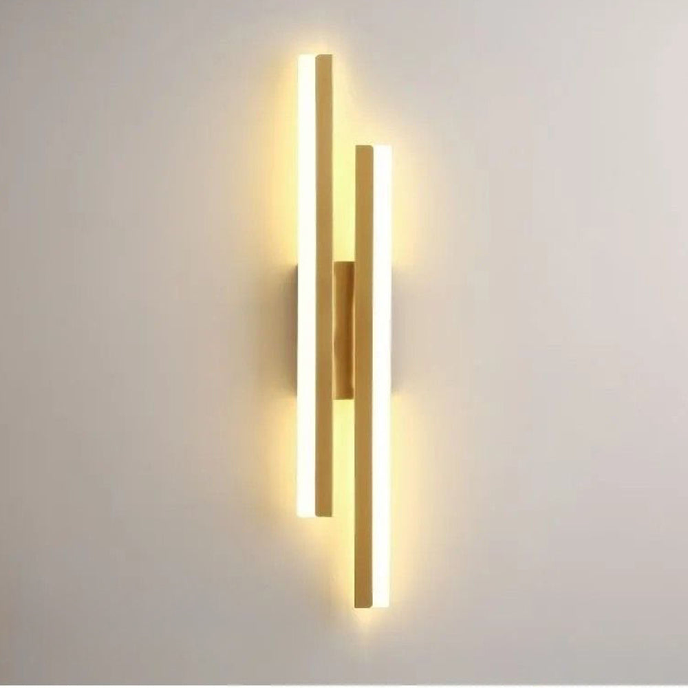 Glowing milor gold asymmetrical LED wall light highlighting the premium metal finish and bright acrylic diffusers