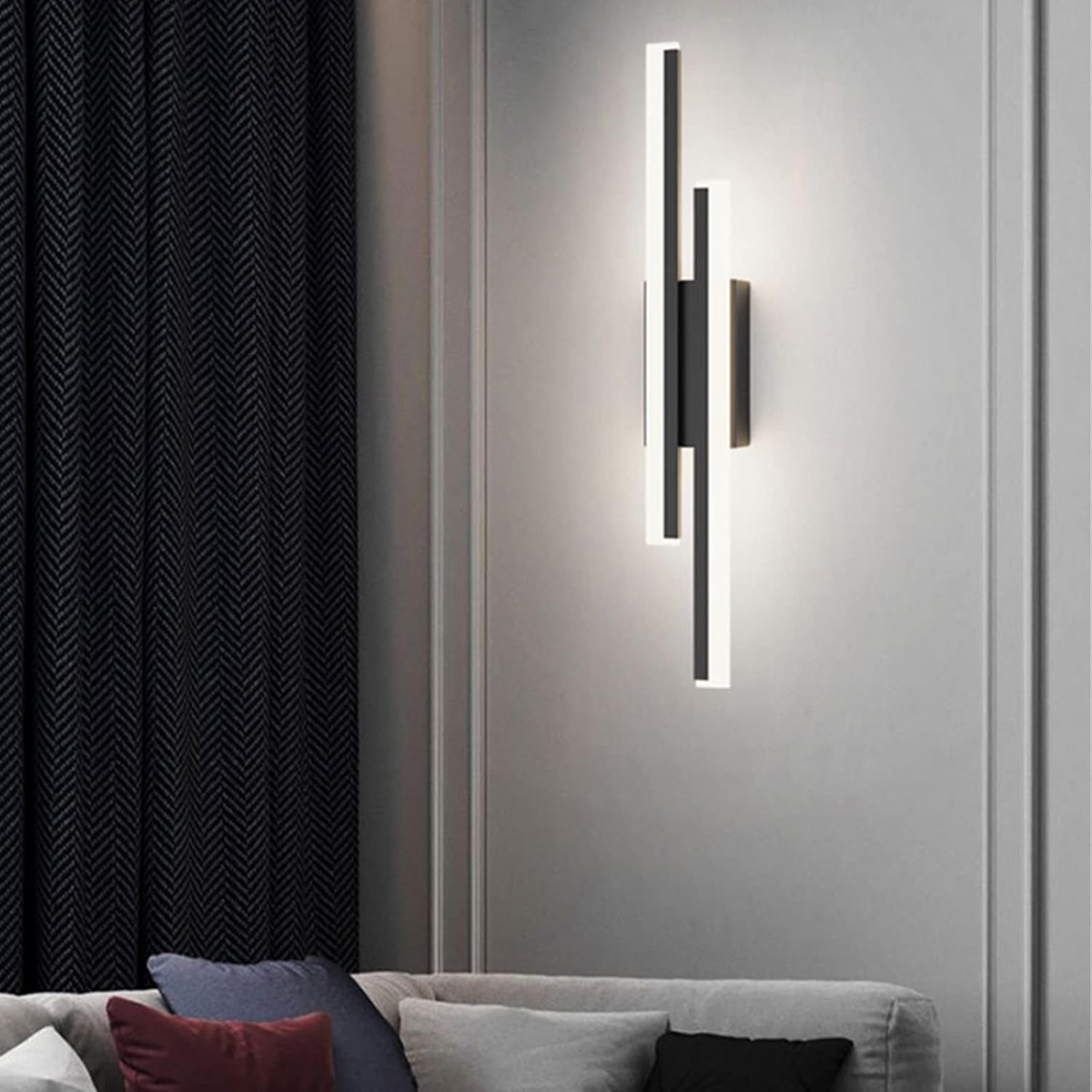 Tall milor black linear wall sconce providing soft ambient lighting in a modern living room setting