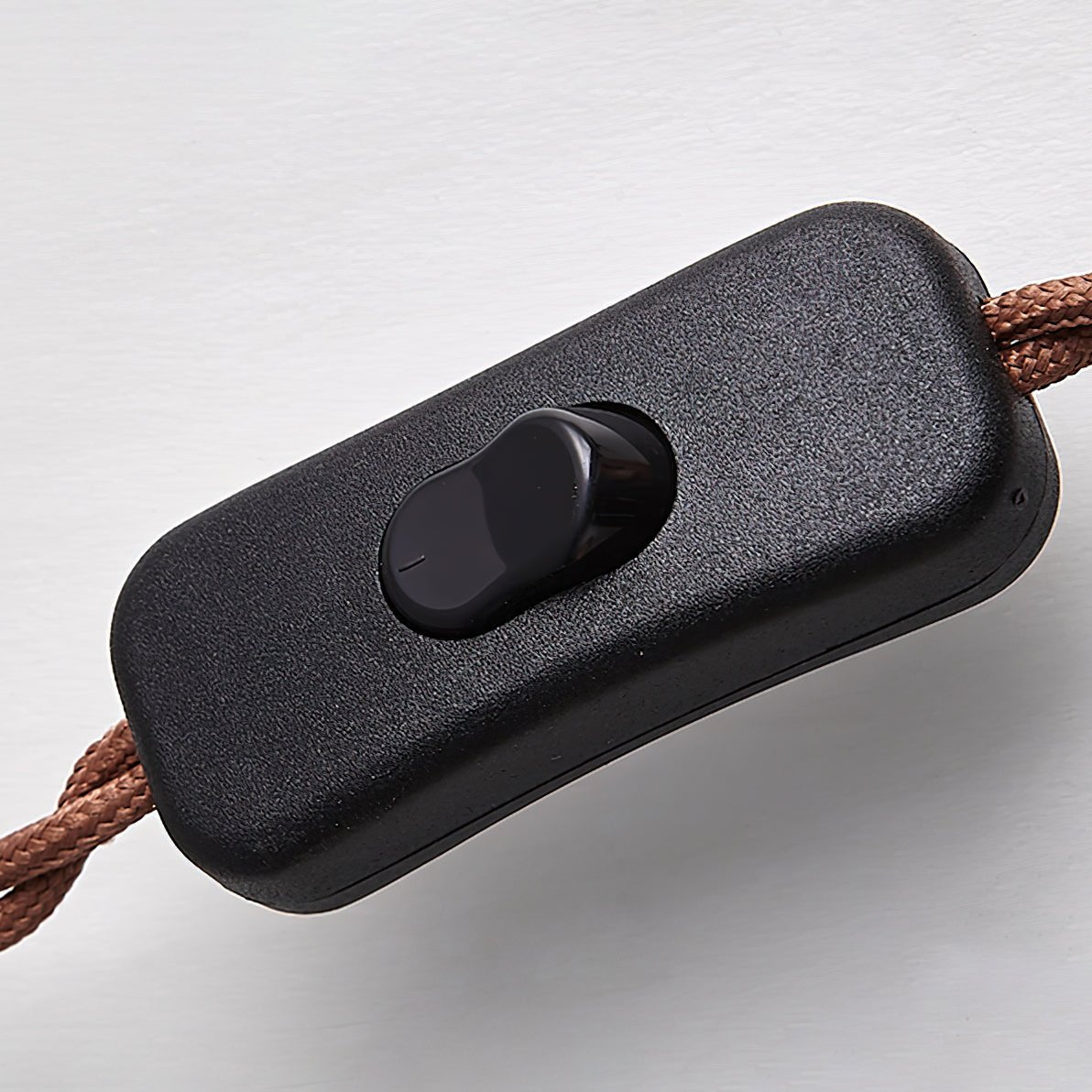 misa close-up of the black inline on/off push-button switch attached to the premium brown braided power cable