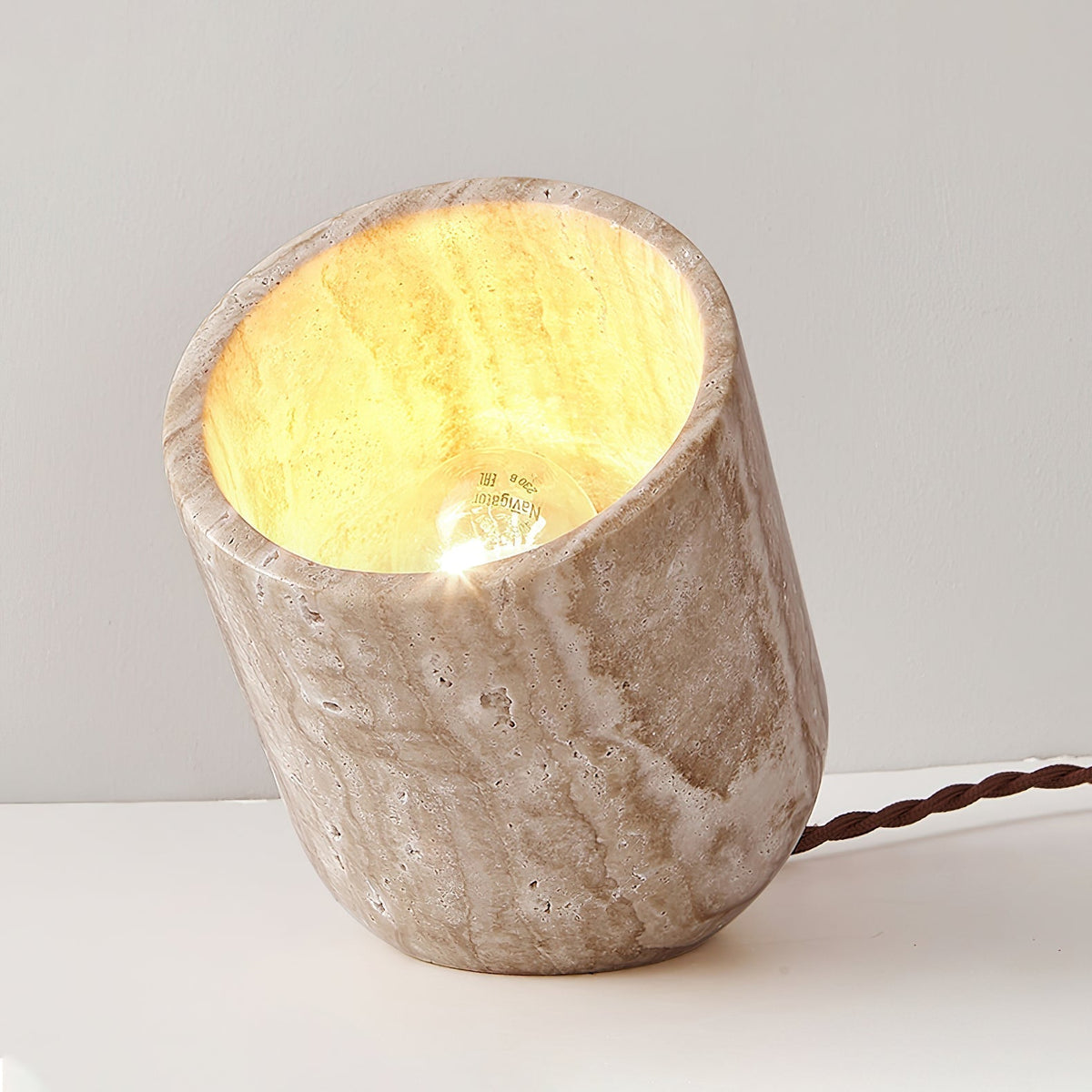 Top-down view into the travertine misa table lamp highlighting the raw stone rim and internal light source