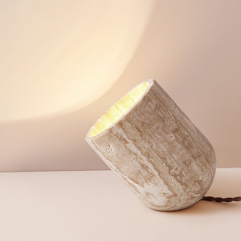 Wabi-Sabi travertine accent misa light illuminating a warm, atmospheric glow against a plain wall