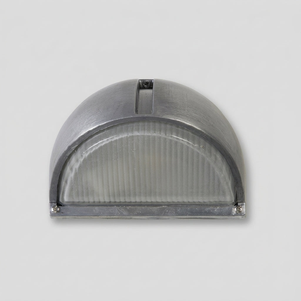 A semi-circular industrial outdoor wall light fixture with a brushed metal dome shade and a ribbed translucent glass diffuser, shown against a neutral light grey background.