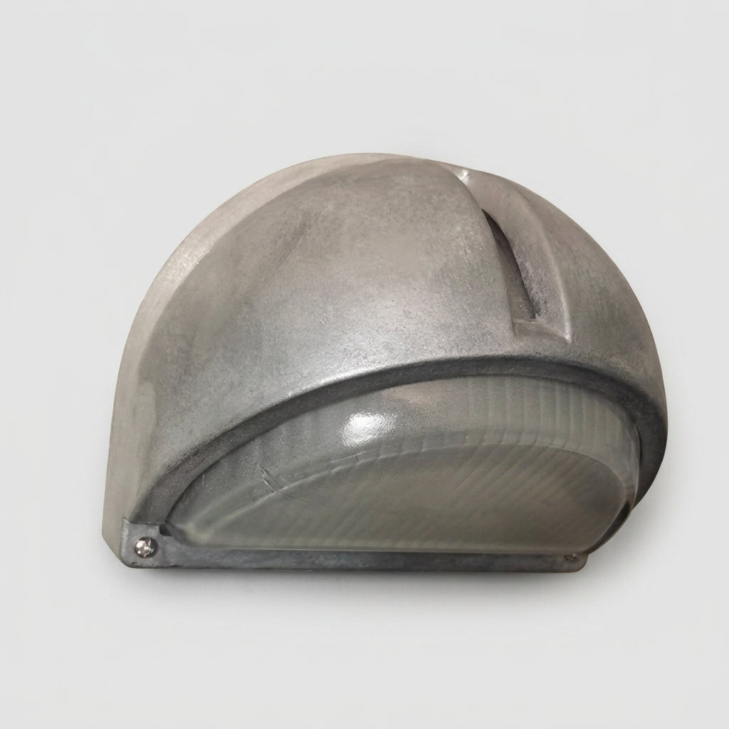 A semi-circular industrial outdoor wall light fixture with a aluminum metal dome shade and a ribbed translucent glass diffuser, shown against a neutral light grey background.