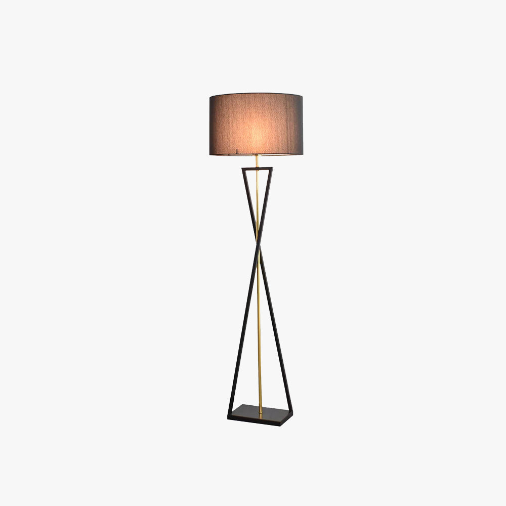 Isolated view of the black mopij hourglass metal floor lamp featuring a warm illuminated fabric drum shade