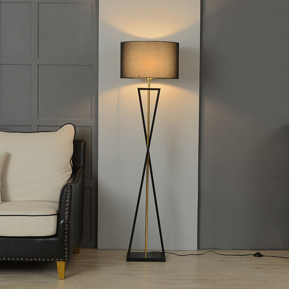 Modern geometric mopij tripod floor lamp with a black fabric shade illuminating a contemporary living room corner