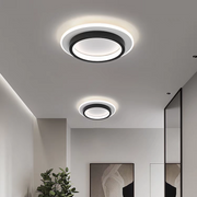Two modern black geometric halo LED flush mount mura ceiling lights illuminating a contemporary hallway