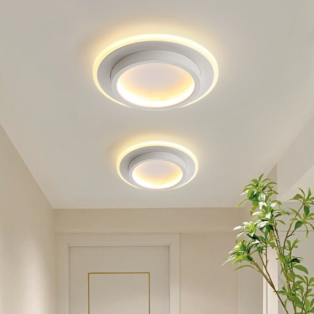 Two modern white geometric LED flush mount mura ceiling lights illuminating a bright corridor