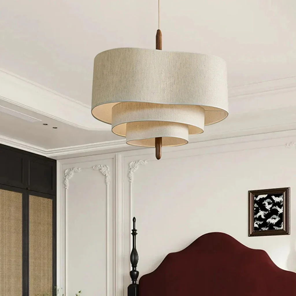 Tiered fabric myska chandelier acting as an elegant, tranquil focal point in a modern bedroom with a burgundy headboard