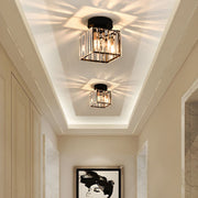 Two modern black square crystal prism flush mount netyf ceiling lights illuminating a bright hallway with a starburst pattern