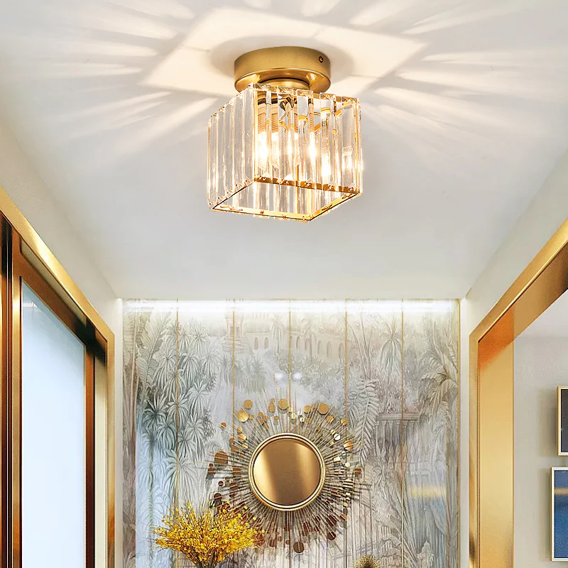 Modern gold square crystal netyf ceiling fixture installed above a living room doorway