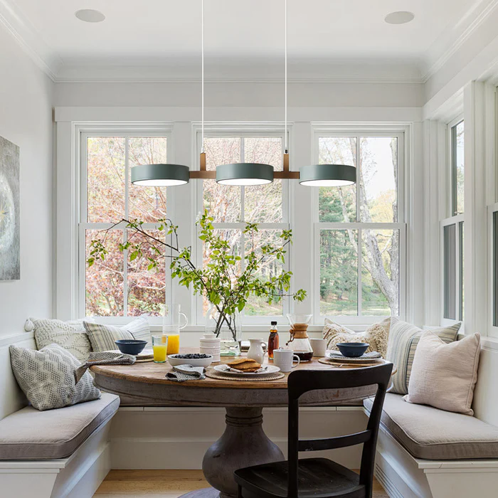 Solid green linear nohit pendant light hanging in a bright, naturally lit dining nook