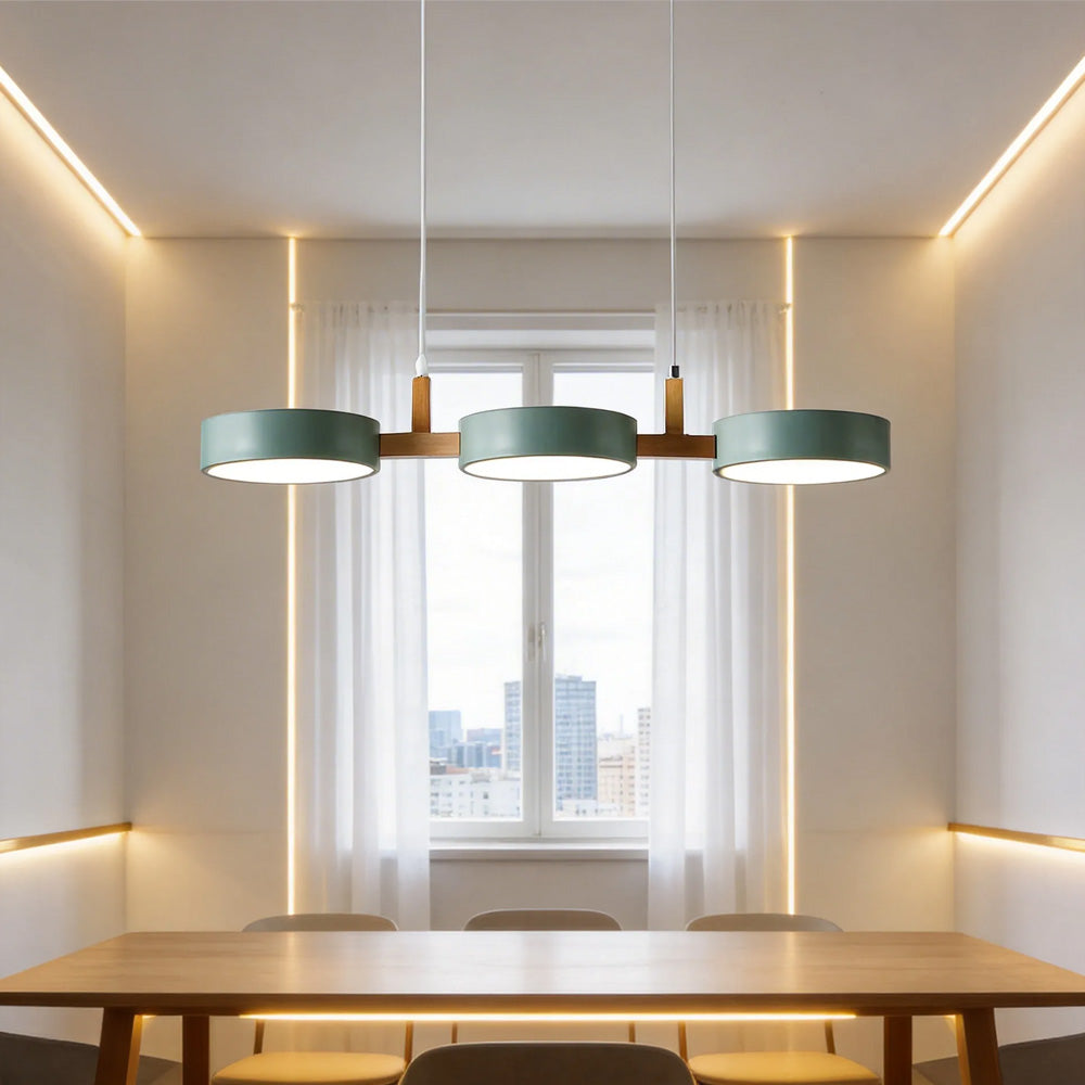 Solid green 3-light nohit pendant providing warm light over a window seat dining area