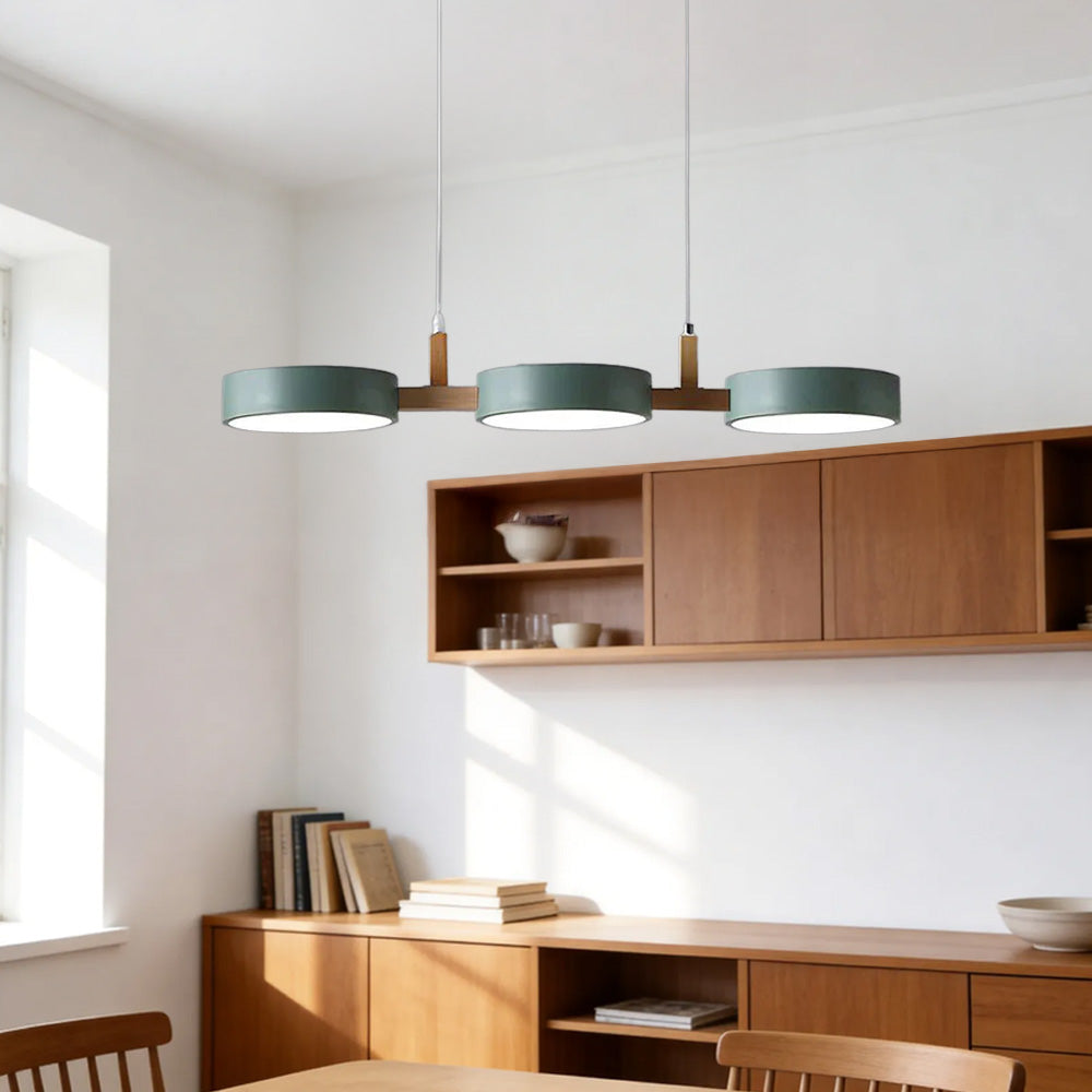 Solid wood and metal linear green nohit pendant illuminating a bright modern kitchen island