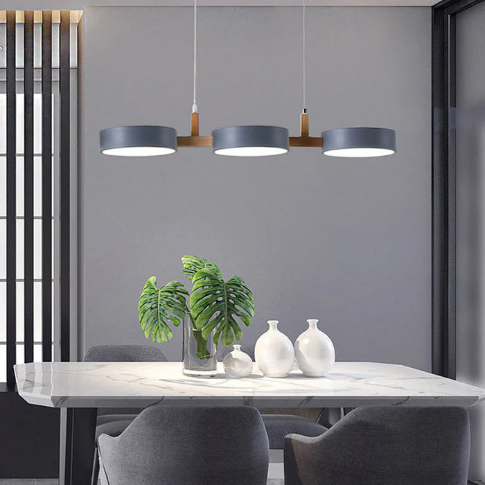 Solid grey 3-light nohit pendant providing even illumination over a marble dining table