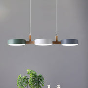 Modern white, grey, and green 3-light Nordic nohit linear pendant suspended over a sleek dining table