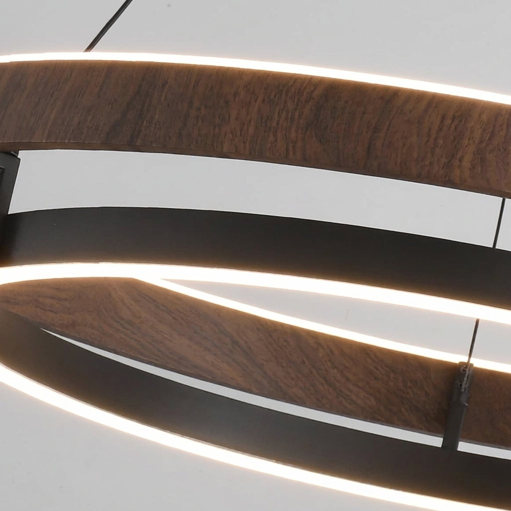 Close-up of the Nyles chandelier glowing LED ring between the wood-grain and black rings