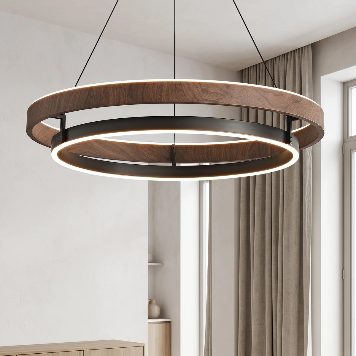 Close-up of the Nyles wood-grain two-ring LED chandelier glowing beside a linen curtain