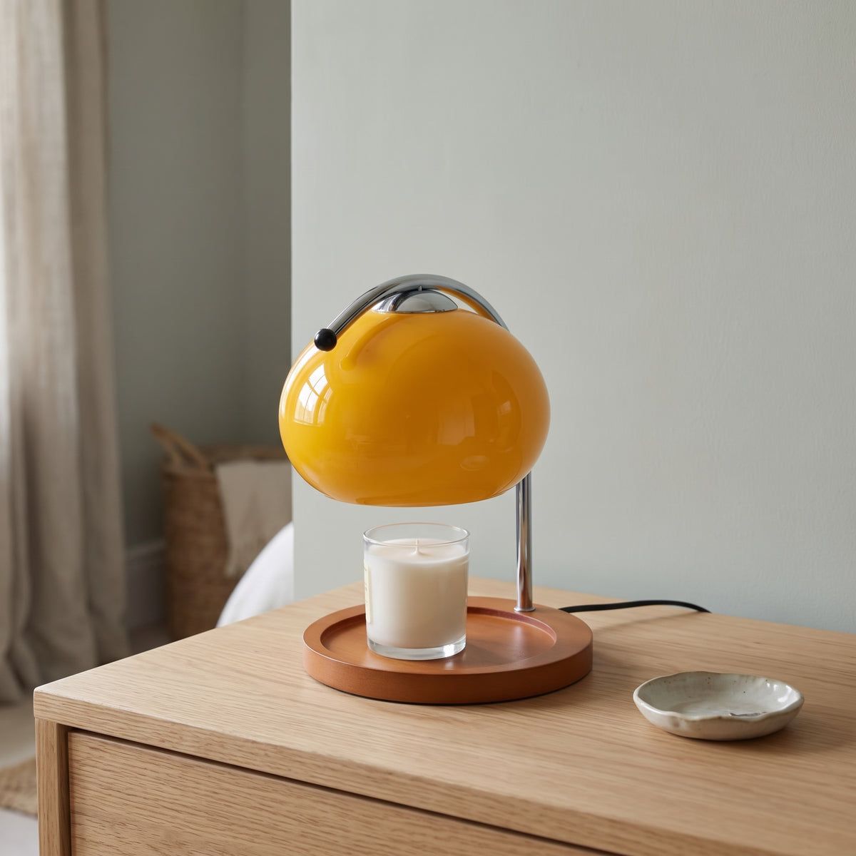 Ondo yellow glass candle warmer lamp on an oak dressing table beside a ceramic trinket dish