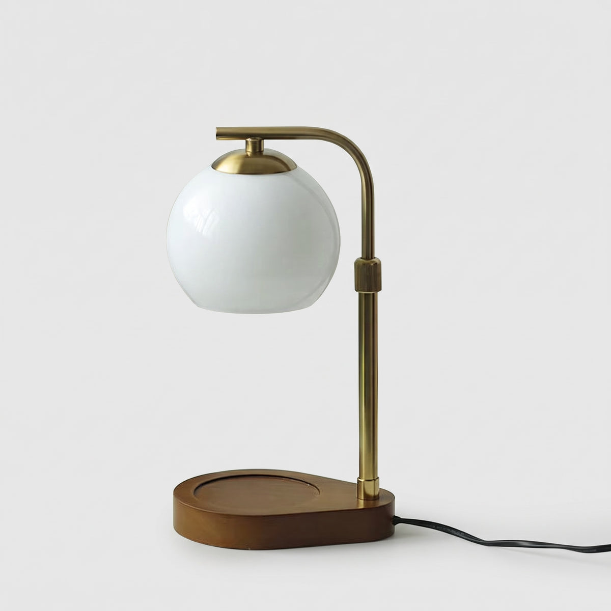 Orsa white glass globe candle warmer lamp with a dark wooden base on a light grey studio background