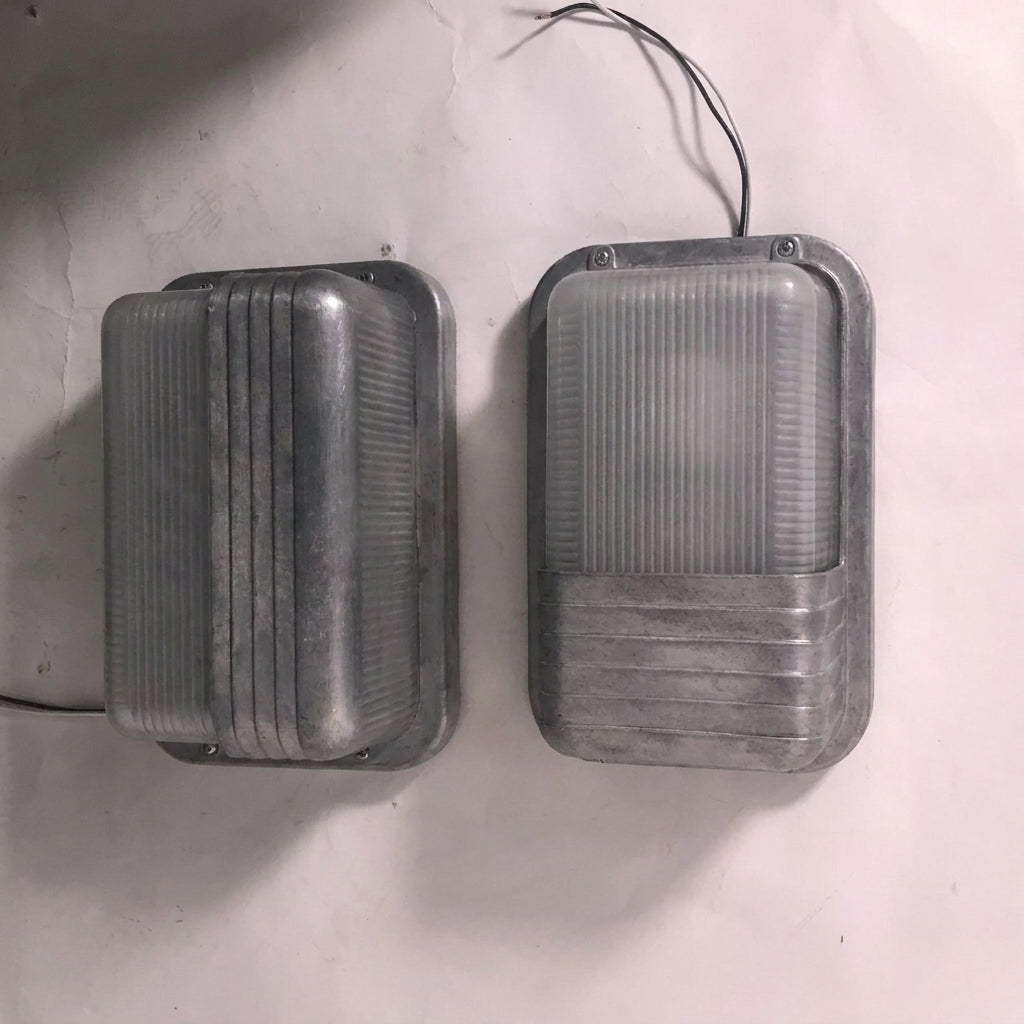 Two Ostin portrait bulkhead wall lights side by side on a white wall