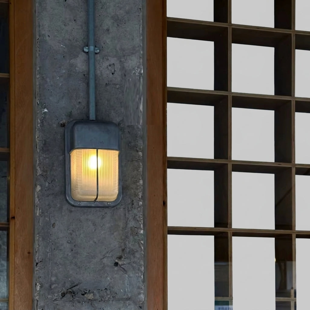 Ostin portrait centre bar hood bulkhead wall light lit on a concrete pillar beside a lattice screen
