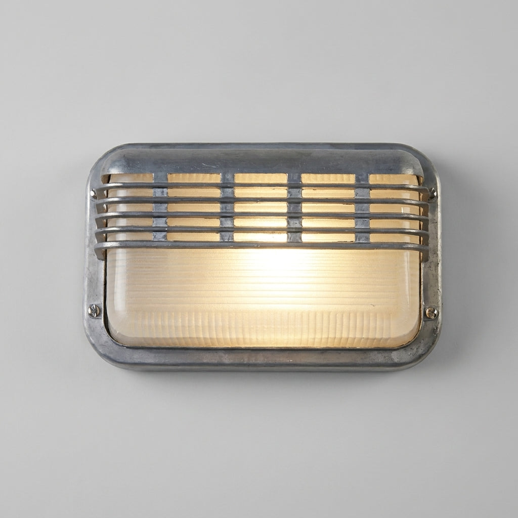 Ostin landscape louvred cage bulkhead wall light lit on a grey wall