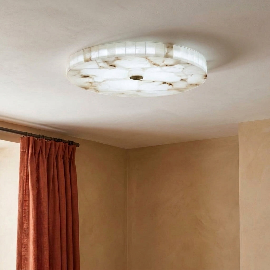 A round marble flush-mount ceiling light fixture shown installed on a textured beige ceiling in a room with rust-coloured curtains.