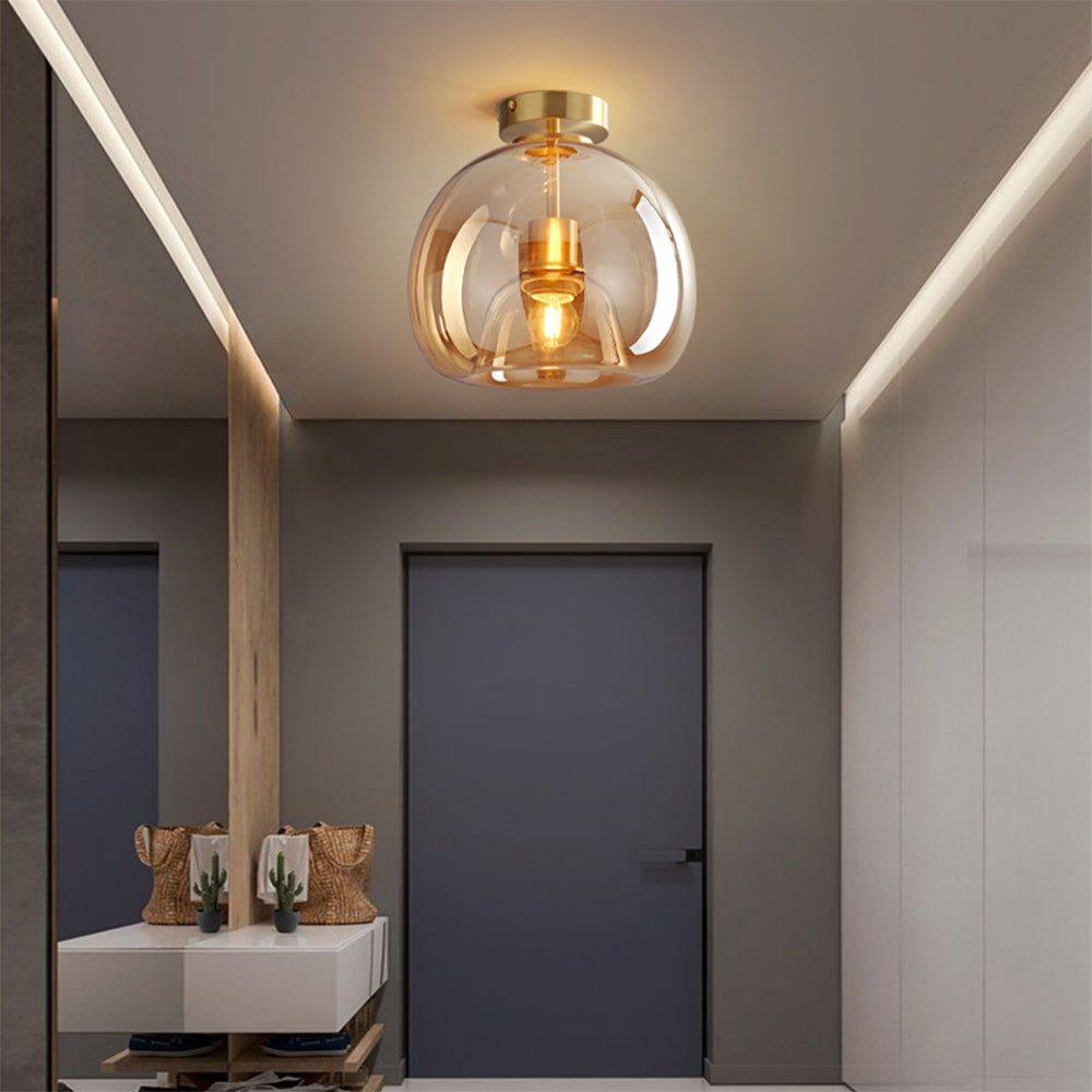 Warm amber glass compact flush mount pawo ceiling light above a modern vanity washroom space