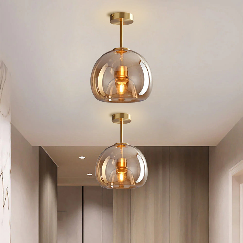 Pair of compact amber tinted glass pawo ceiling lights in a bright, warm hallway corridor