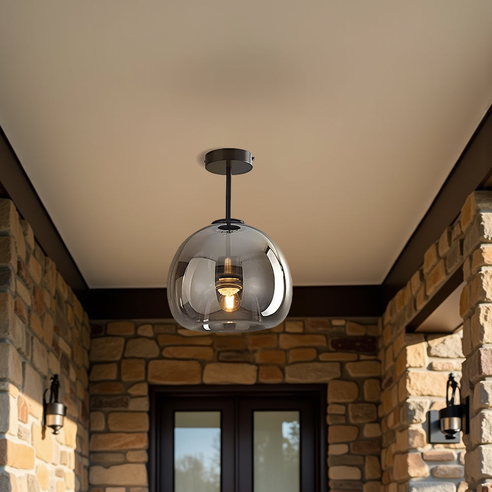 Tall smoke grey glass dome pawo ceiling light providing ambient illumination on a covered porch entryway