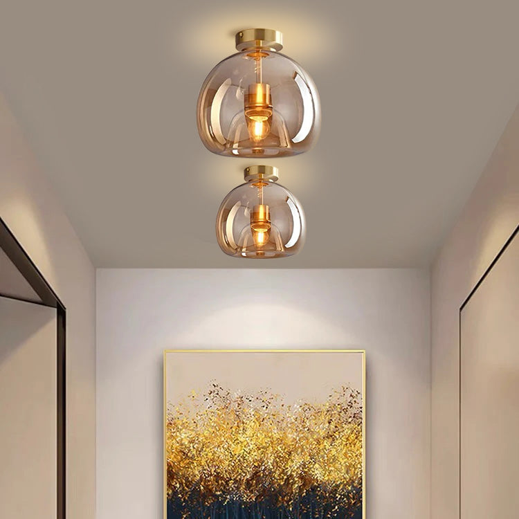 Two tall elegant amber glass dome pawo ceiling lights illuminating a contemporary home interior