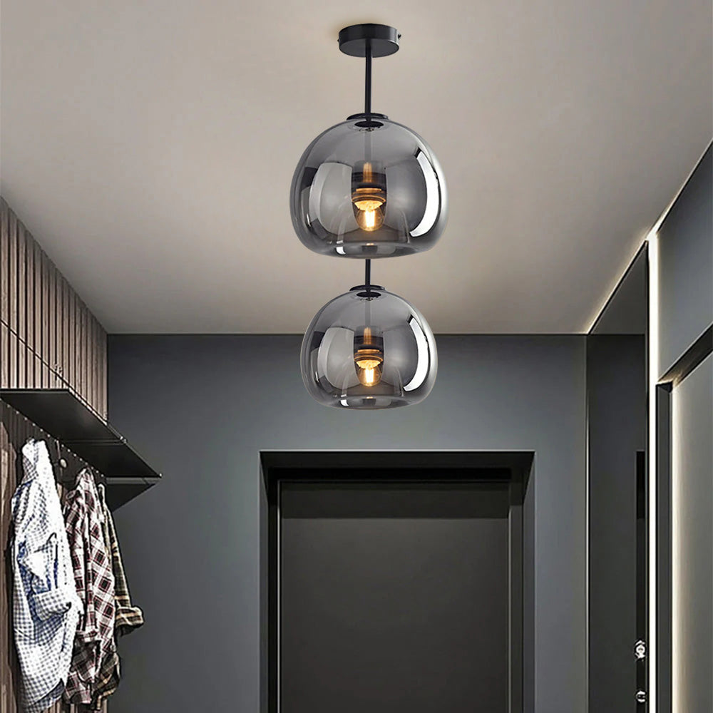 Two tall 29cm smoke grey glass dome flush mount pawo lights illuminating a dark modern corridor