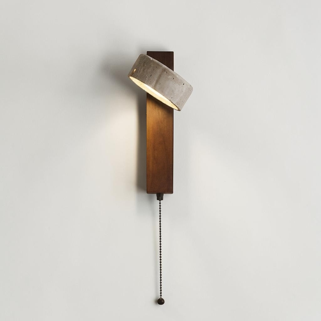 Pexni wall light side angle view, illuminated stone shade with pull chain switch, studio grey background