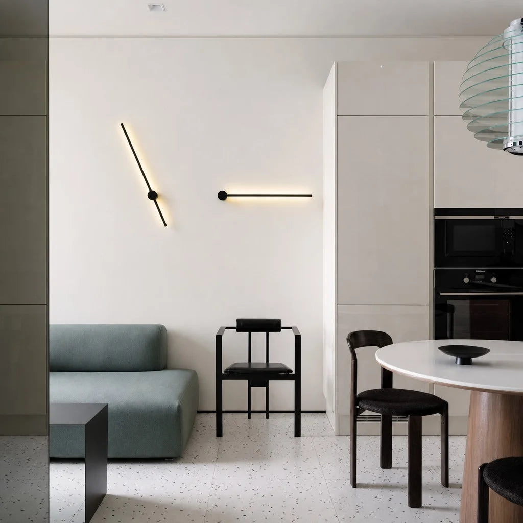 Adjustable pila linear LED wall sconces mounted at creative angles in a modern open-plan dining and living area