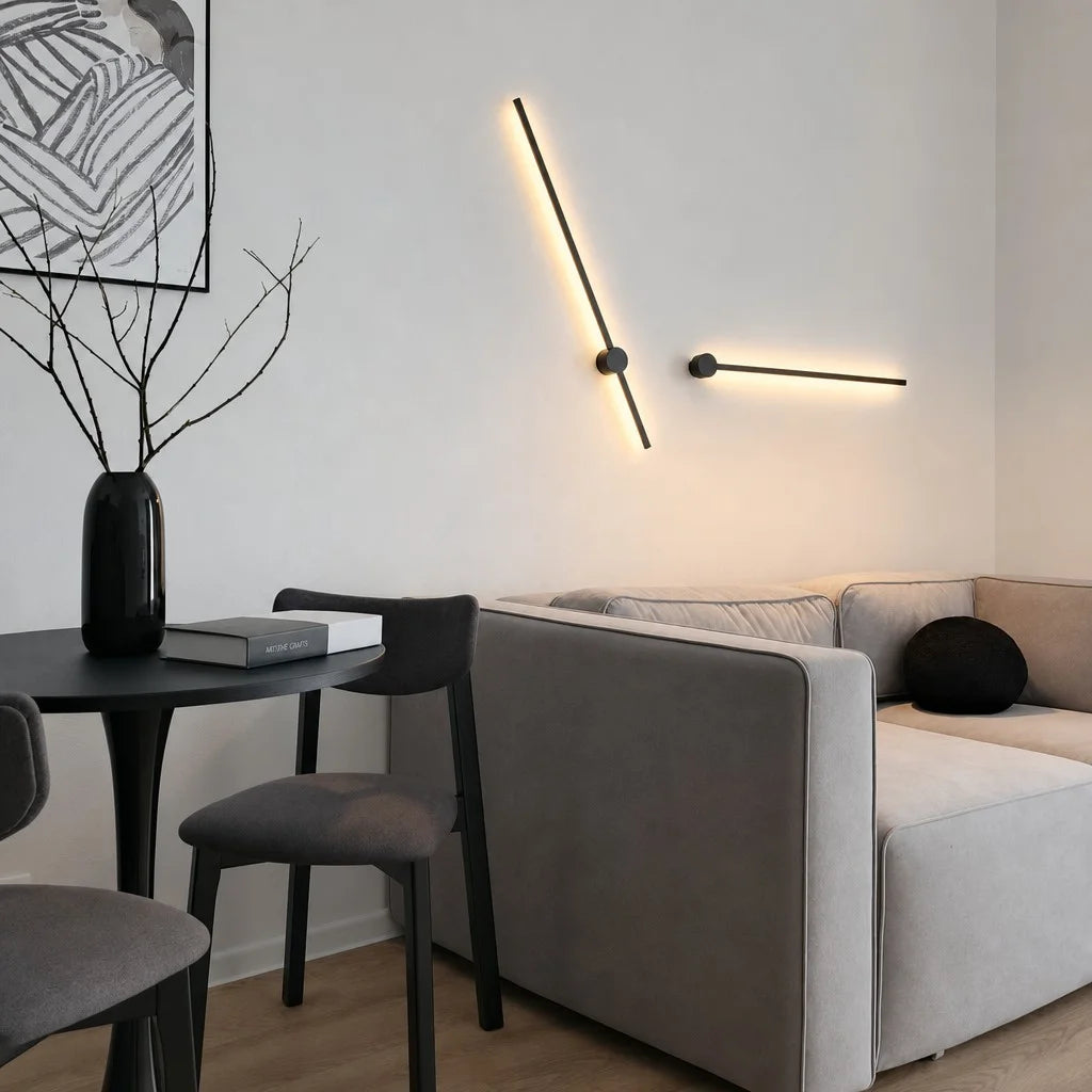 Sleek linear pila wall sconce rotated at a dynamic 45-degree angle above a modern grey sofa