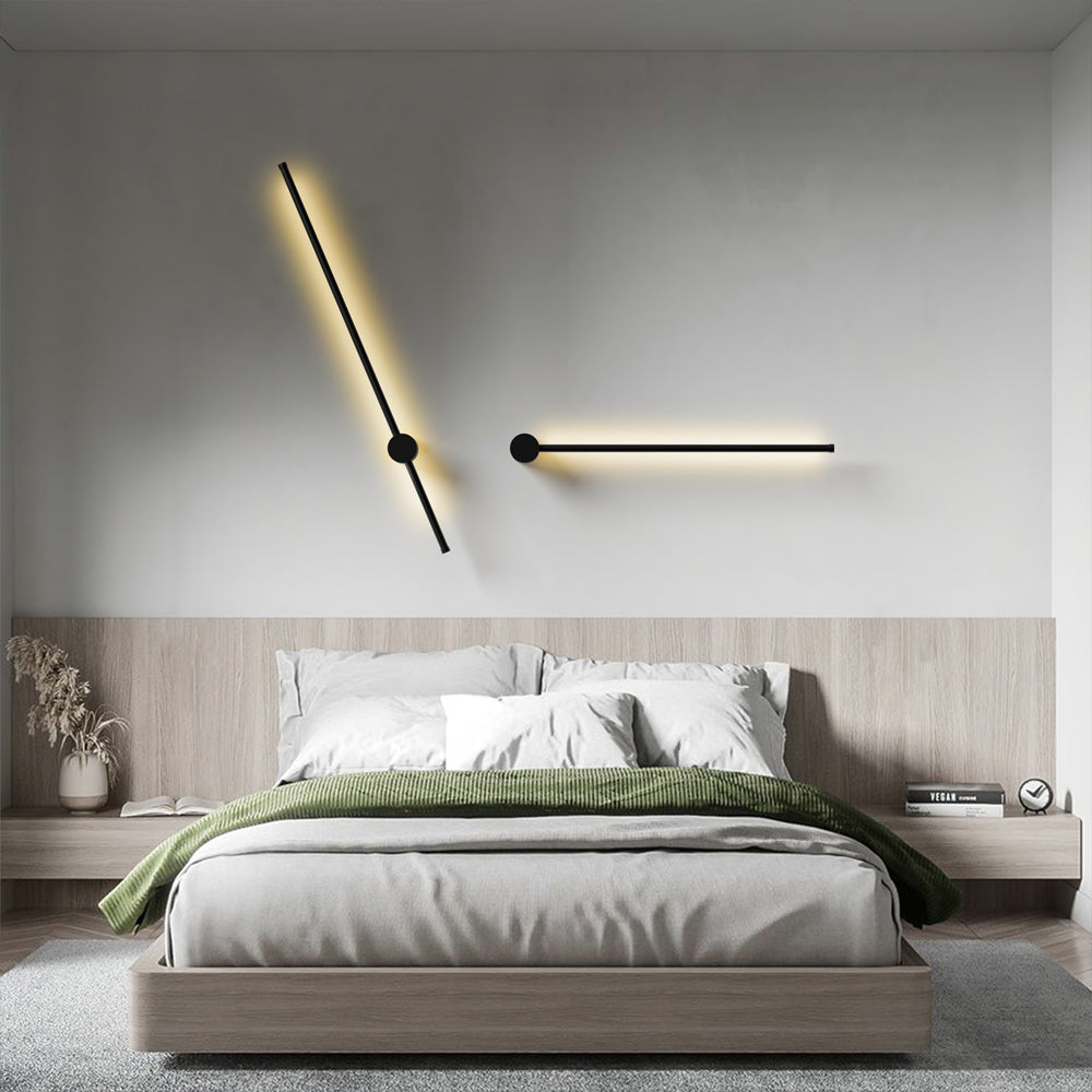 Pair of pila rotatable linear LED sconces styled horizontally and diagonally over a modern bedroom headboard