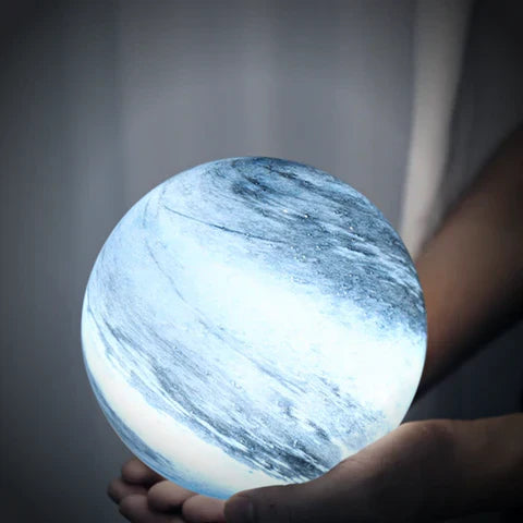 Person holding the compact blue celestial pilo glass sphere lamp in their hands to show its perfect scale