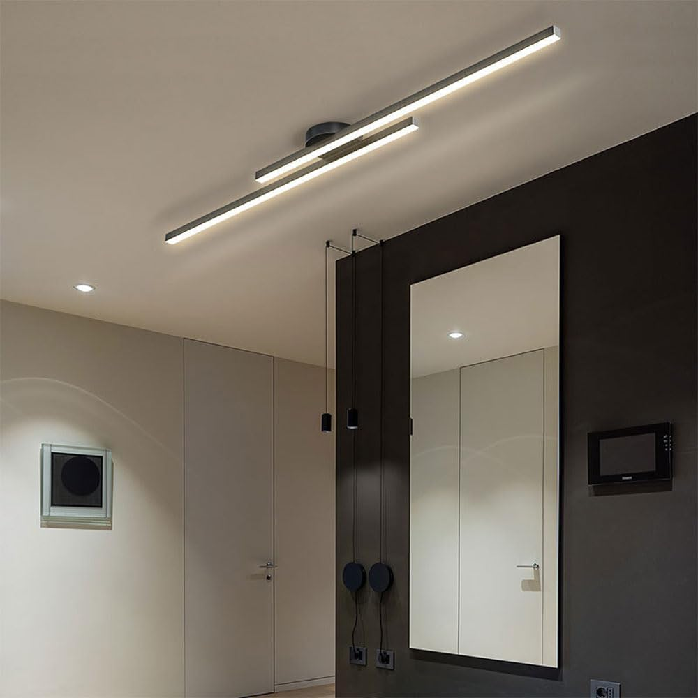 Black double-bar poxu ceiling light acting as a modern centrepiece over a dining area