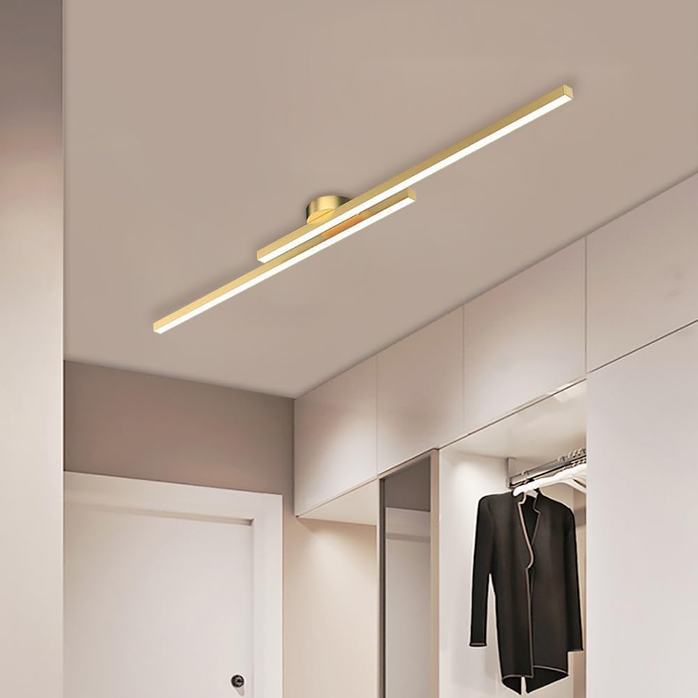 Gold staggered poxu linear LED ceiling light providing a sophisticated glow in a modern entryway