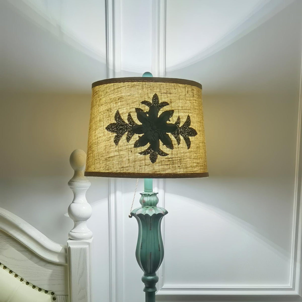 Close-up detail of the puska illuminated vintage fabric lampshade and sculpted green resin column
