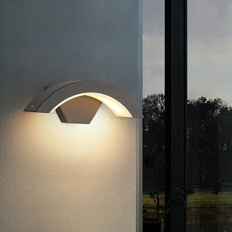 Curved black qaxo LED outdoor lighting fixture mounted on a modern architectural pillar