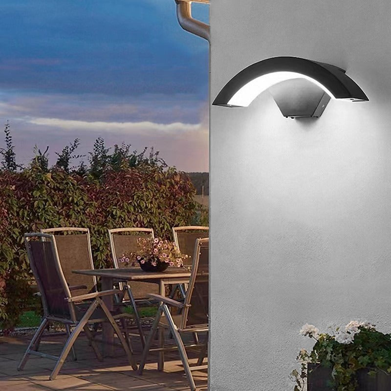 Arched qaxo LED wall lighting illuminating an outdoor patio and dining area at twilight