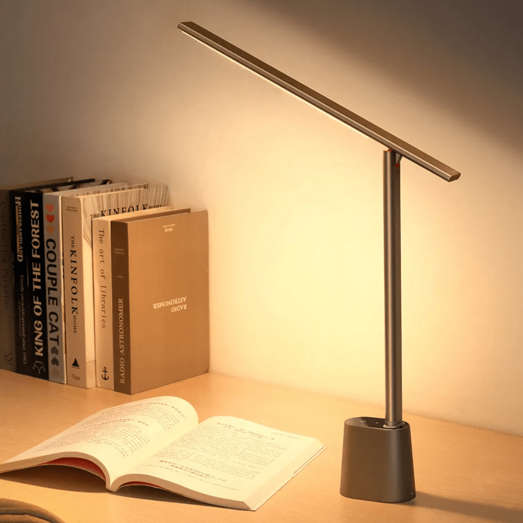 Modern black foldable qeta LED desk lamp providing glare-free reading light over an open book