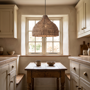 Relton 30cm rattan pendant light above a small wooden table in a British cottage kitchen