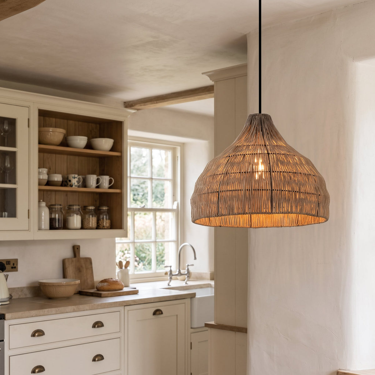 Relton rattan pendant light hanging in a British cottage kitchen with cream cabinets