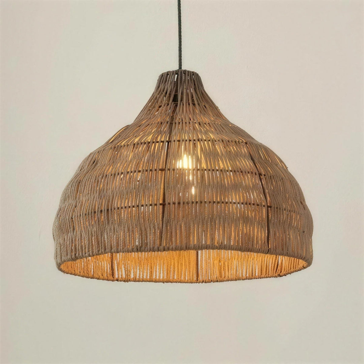 Relton handwoven natural rattan pendant light shade, lit with a warm glow, against a plain background
