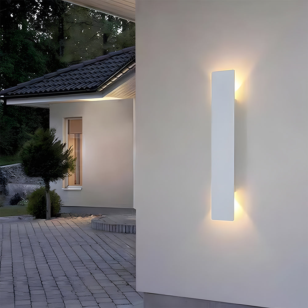 White reta IP65 exterior wall light illuminating the corner wall of a residential driveway